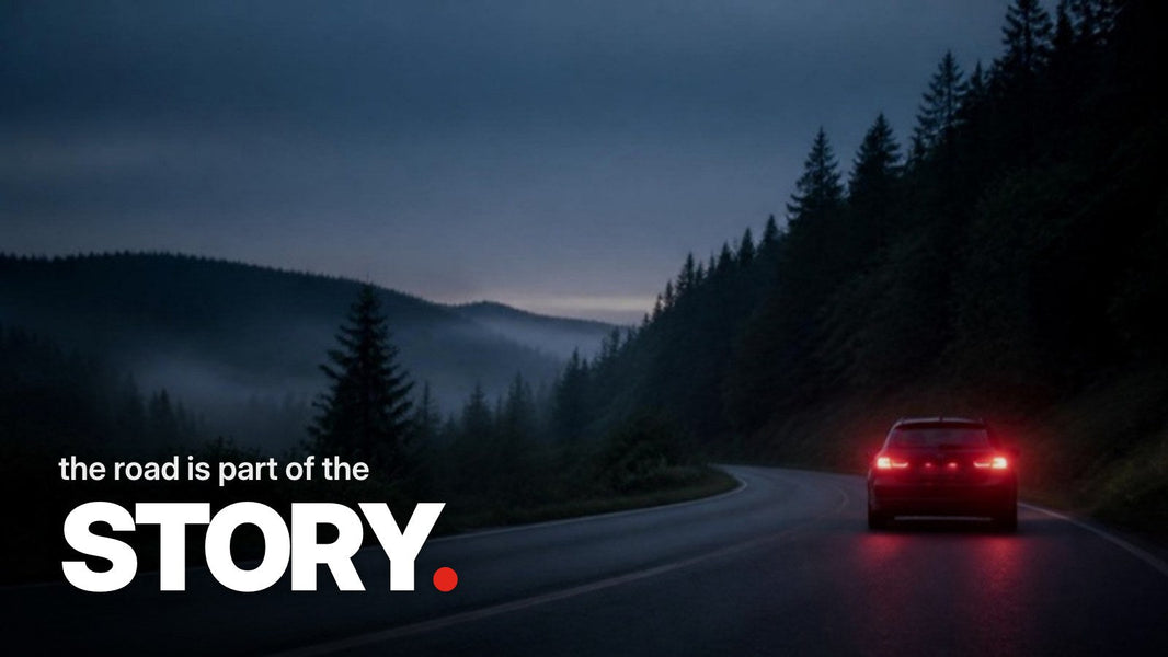 Text 'the road is part of the STORY.' above a photo of a dark car with red taillights driving on a foggy, winding country road through an Eifel forest at dusk.