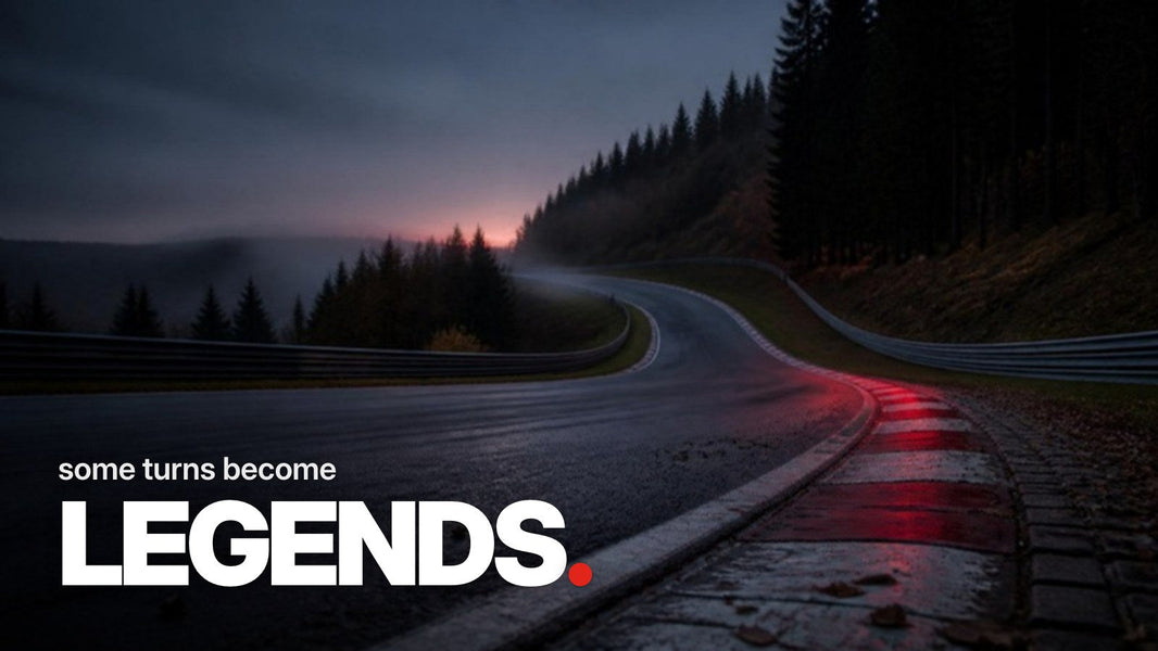 Text 'some turns become LEGENDS.' above a photo of an empty, uphill race track curve with red-and-white curbs disappearing into the evening mist between dark forests.