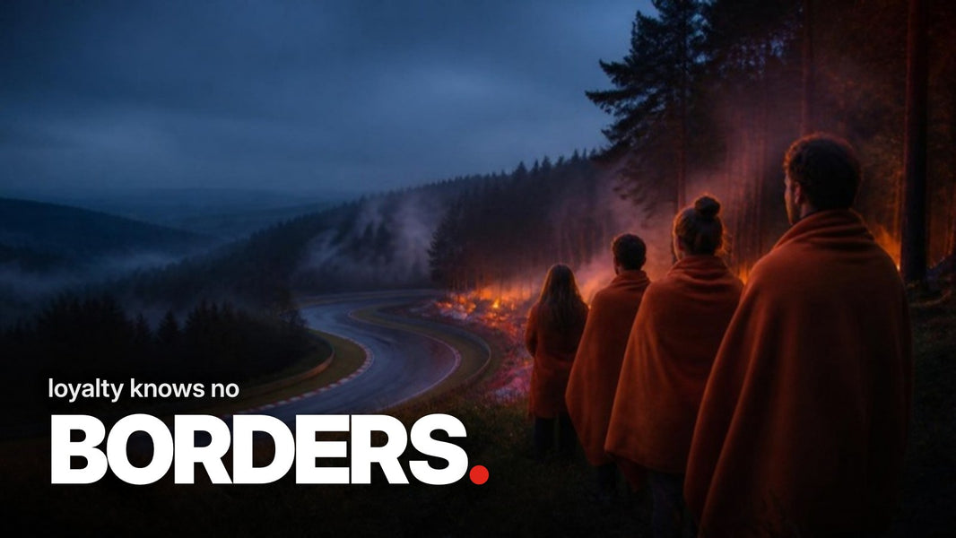 Text 'loyalty knows no BORDERS.' above a photo of fans in orange blankets watching an empty race track with red-and-white curbs from a misty forest slope in the Eifel at dusk.