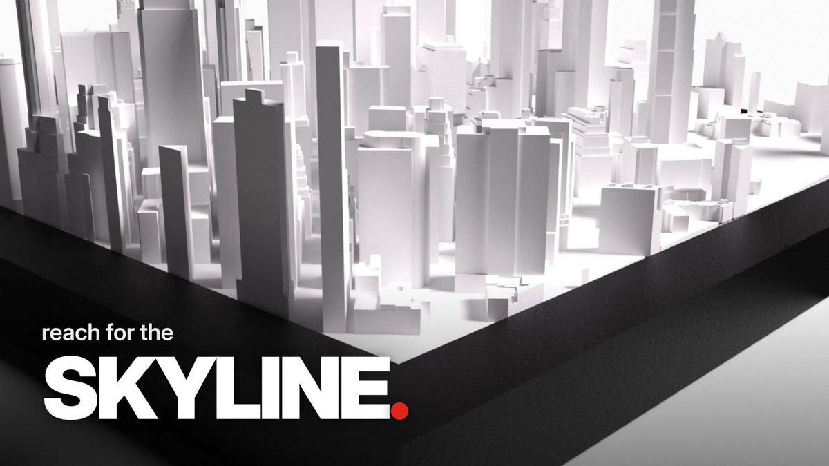 Schriftzug ‚reach for the SKYLINE.‘ über einer Detailaufnahme des City Tile New York mit flachem Blick über die Rahmenecke auf die weißen 3D-Wolkenkratzer Manhattans.