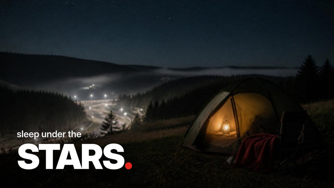 Text 'sleep under the STARS.' over a nighttime photo of a lit tent on a spectator hill in the Eifel, with a misty, floodlit racetrack in the valley behind.