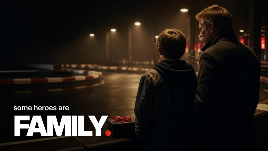 Schriftzug ‚some heroes are FAMILY.‘ über einem Foto eines Mannes, der mit einem von hinten gezeigten Kind an einer abendlichen Kartbahn steht, neben ihnen ein schwarz verpacktes Geschenk mit roter Schleife.